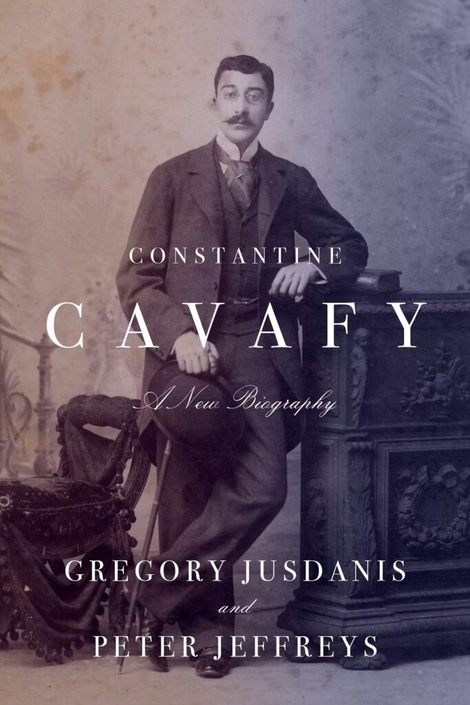 A sepia-toned book cover features a portrait of Constantine Cavafy, a mustached man in a suit, leaning on an ornate table. The title reads Constantine Cavafy: A New Biography by Gregory Jusdanis and Peter Jeffreys.